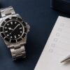 ダイバーズウォッチと購入条件を確認するチェックシート、ルーペを並べたイメージ