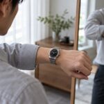 鏡で腕時計と服装のバランスを確認する人物のイメージ