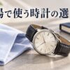 淡い青のシャツと紺色の手帳のそばに、革ストラップの腕時計を置いたAI生成イメージ