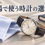 淡い青のシャツと紺色の手帳のそばに、革ストラップの腕時計を置いたAI生成イメージ
